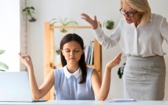 A young woman sits at a desk in a calm, meditative pose with eyes closed, hands raised, and fingers intertwined. An older woman stands behind her, gesturing with frustration. A laptop and notebook are on the desk, and plants decorate the background.