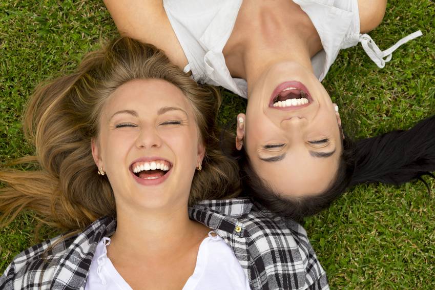 happy women lying on grass
