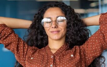 young woman with hands behind her head and eyes closed - illustrating a highly intuitive person