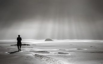 man walking on misty beach