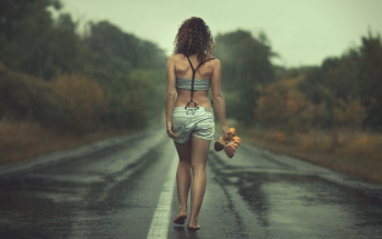 woman walking barefoot along road