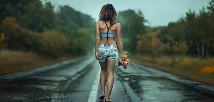 woman walking barefoot along road