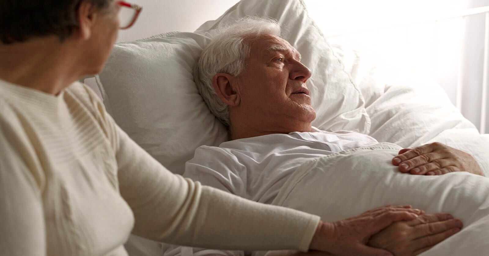 senior man in a hospital bed looking scared