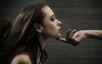 hand holding woman's head - concept of narcissistic superiority