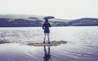 woman with umbrella at lake - concept being humble