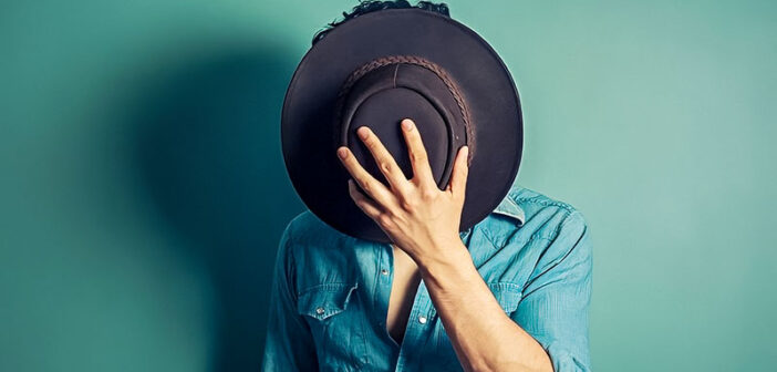 man covering face with hat - concept of covert narcissist