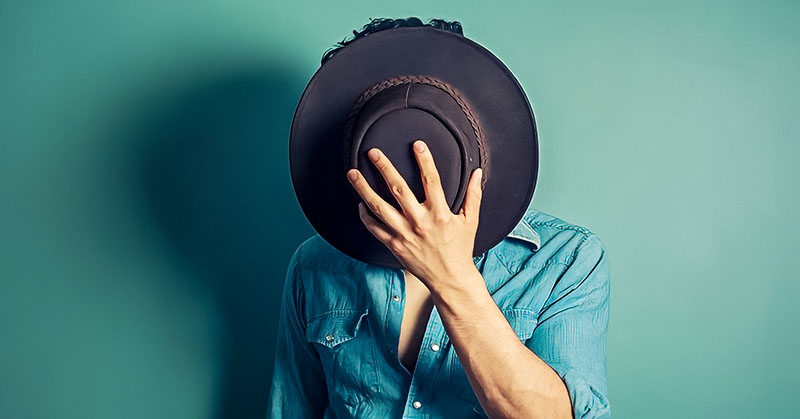 man covering face with hat - concept of covert narcissist