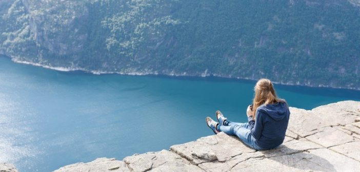 woman sitting on cliff edge - concept inner monologue