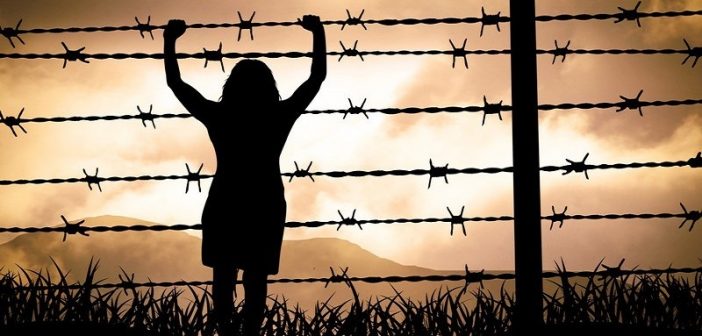 woman trapped by barbed wire fence - concept of victim mentality