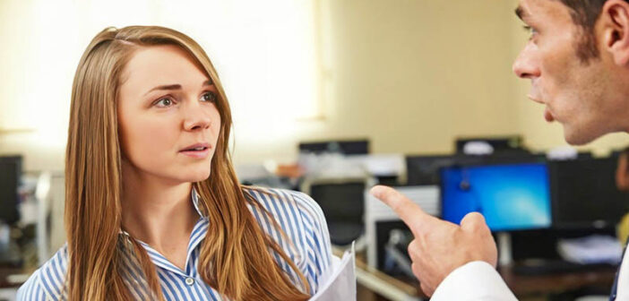 male boss pointing finger at female coworker - concept of control freak