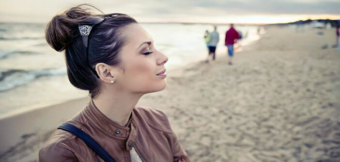 woman eyes closed on beach - concept of highly sensitive person