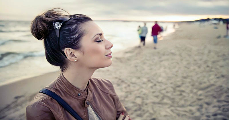 woman eyes closed on beach - concept of highly sensitive person