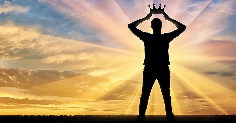 man holding crown above his head - concept of narcissist