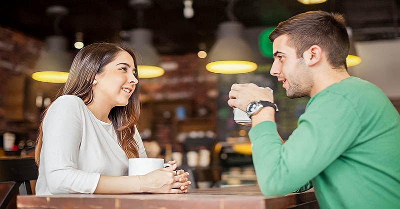 man and woman talking in coffee shop