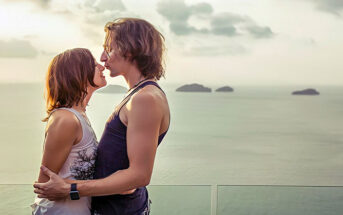 couple standing together with ocean in the backgrounf