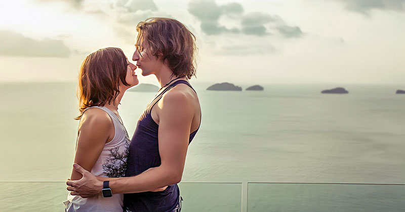 couple standing together with ocean in the backgrounf