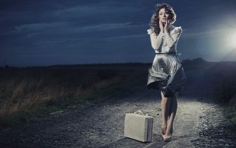 woman with suitcase on dark path - fear of change