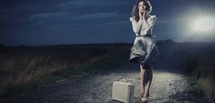 woman with suitcase on dark path - fear of change