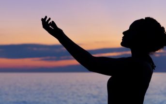 woman arms up to the sky in begging pose - concept of asking the universe