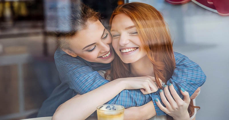 two young women hugging to symbolilze encouragement