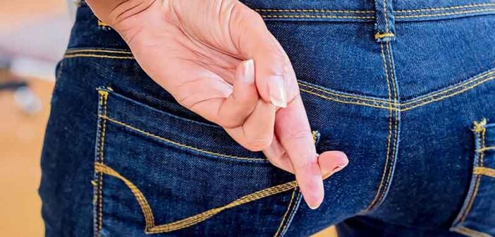 woman with crossed fingers behind back indicating a lie