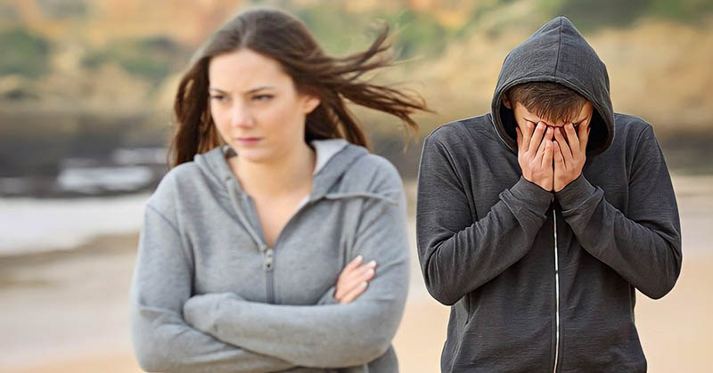 young woman walking away from man after breaking up with him