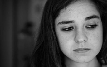 black and white photo of sad looking young woman feeling worthless