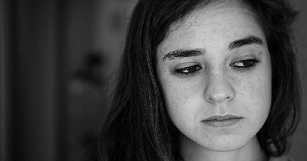 black and white photo of sad looking young woman feeling worthless