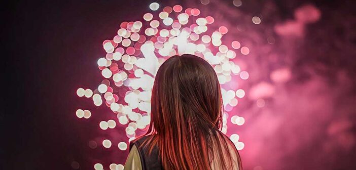 woman looking at fireworks to signify New Year's resolutions