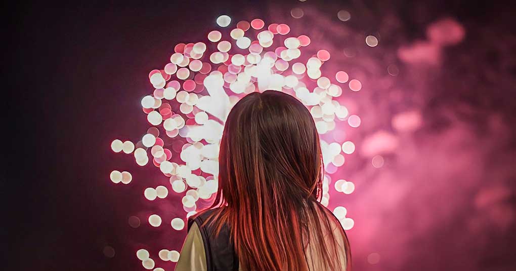 woman looking at fireworks to signify New Year's resolutions