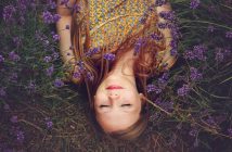 young woman lying in a field of lavender showing a spirit that needs to wake up