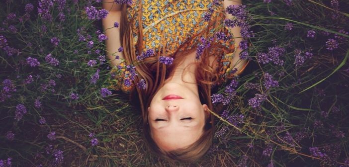 young woman lying in a field of lavender showing a spirit that needs to wake up