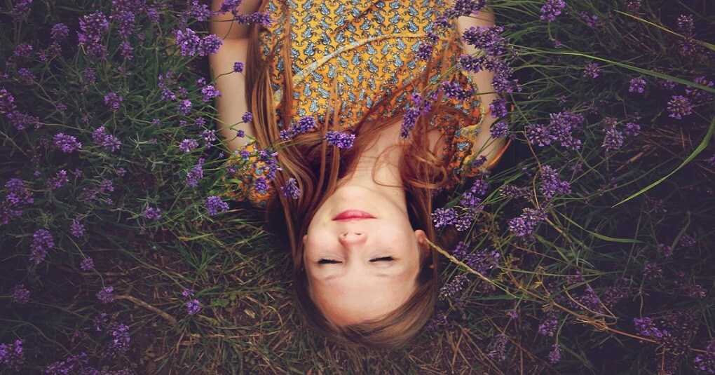 young woman lying in a field of lavender showing a spirit that needs to wake up