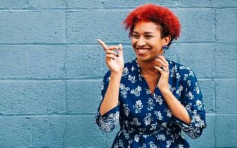 woman smiling and pointing to indicate humor