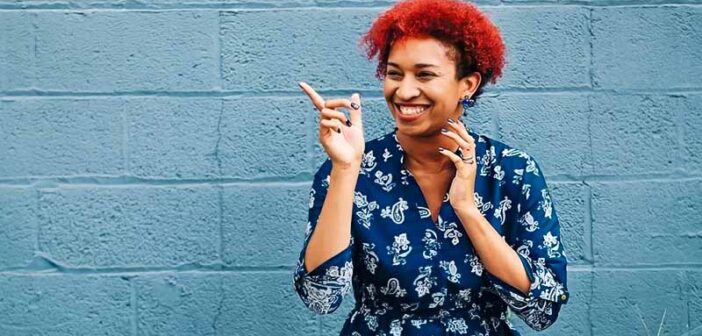 woman smiling and pointing to indicate humor