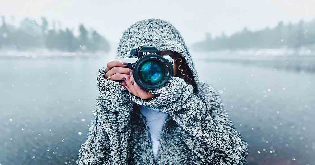 woman in snowy landscape pointing camera toward viewer - concept of free spirit jobs