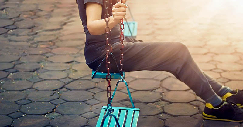 lonely woman on playground swing who has driven her friends away