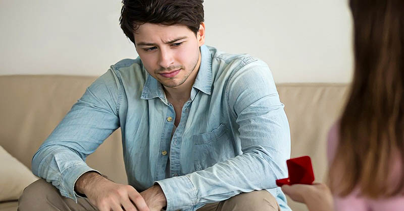 woman proposing to man who looks very unsure - signifying commitment issues