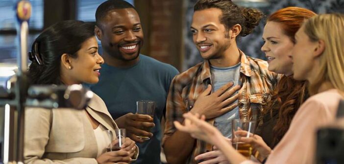 group of men and women talking at a bar