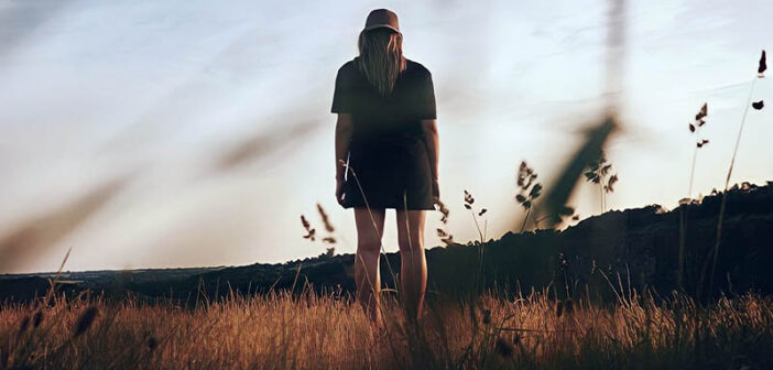 lone woman walking in field indicating abandonment issues