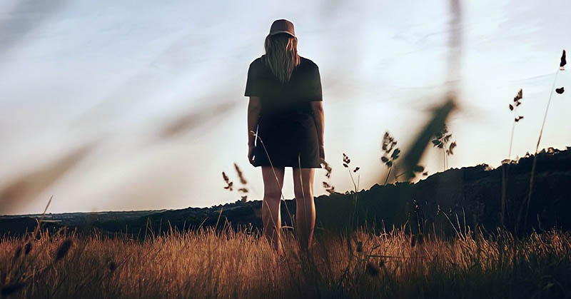 lone woman walking in field indicating abandonment issues