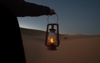 man holding lantern in desert