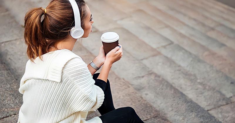 loner woman sitting on steps drinking coffee