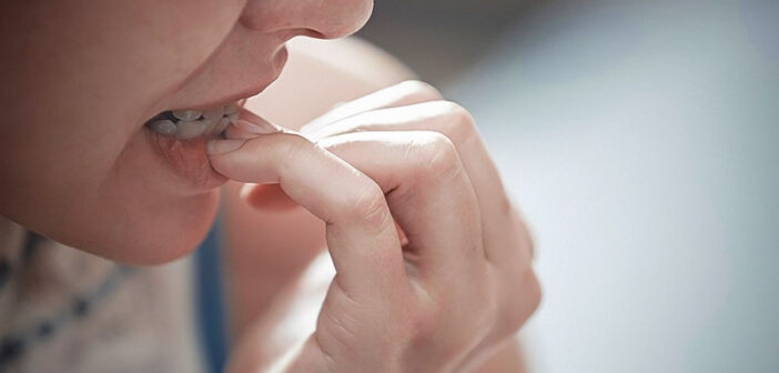 woman biting finger nails an an example of a nervous habit