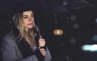 young woman carrying umbrella in the rain