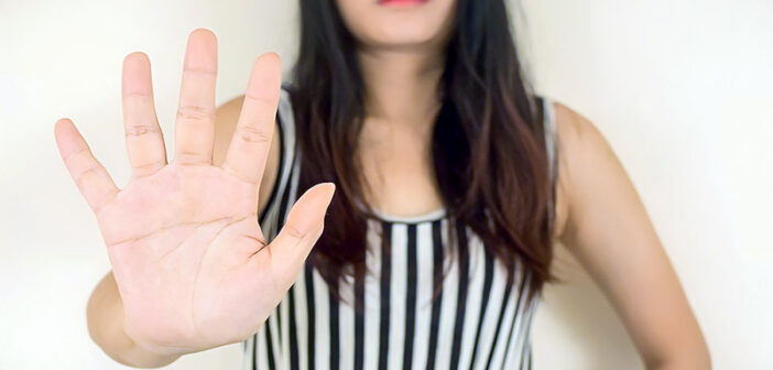 young woman with outstretched palm signalling her saying no to someone
