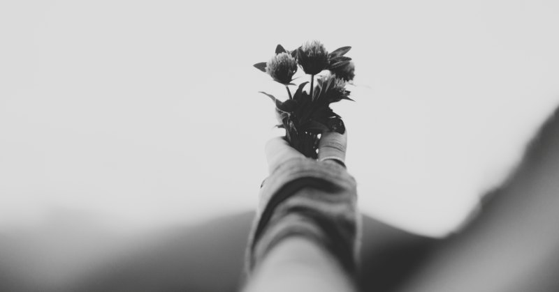 a person holding flowers to symbolize death