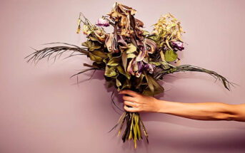 outstretched hand with bouquet of dying flowers
