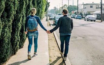 couple holding hands on sidewalk