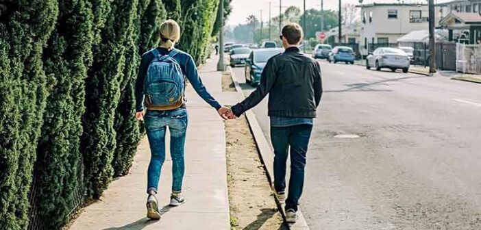 couple holding hands on sidewalk